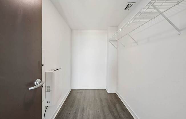 A room with a brown door and a white wall.