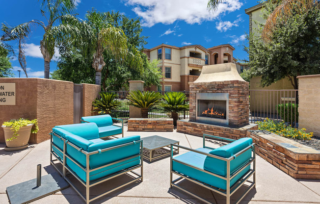 A patio with a fireplace and two chairs.