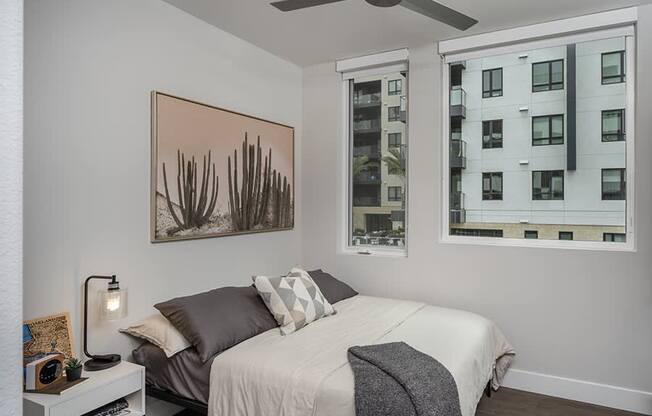a bedroom with a bed and two windows