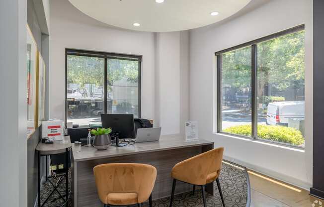 an office with chairs and a desk with a laptop on it