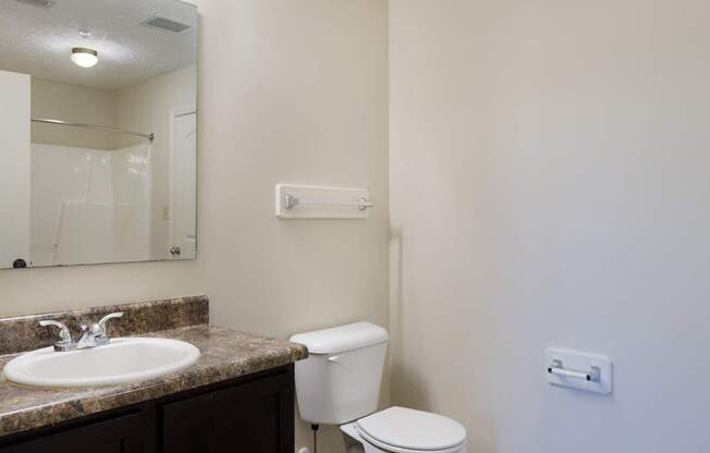 A white toilet sits next to a sink in a bathroom.