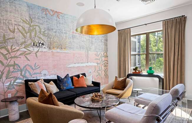 a living room with a couch and chairs and a large wall mural