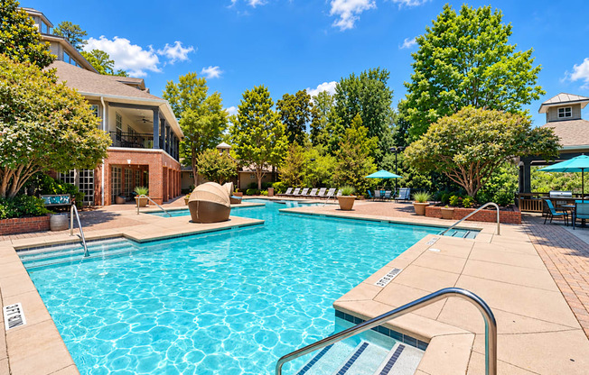Swimming pool with entry steps, lounge chairs, and umbrella-covered outdoor seating at Elevation 3505 in Atlanta, GA.