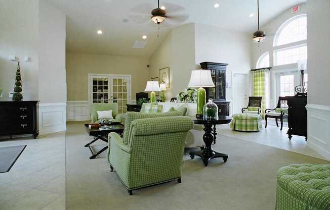 A living room with a green chair and a black dresser.