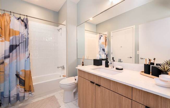 A bathroom with a toilet, sink, and shower curtain.