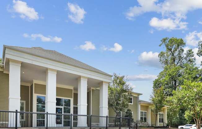 A house with a black fence and white columns.