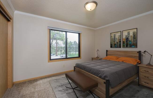 a bedroom with a large window and a large bed. Fargo, ND Birchwood 2 Apartments