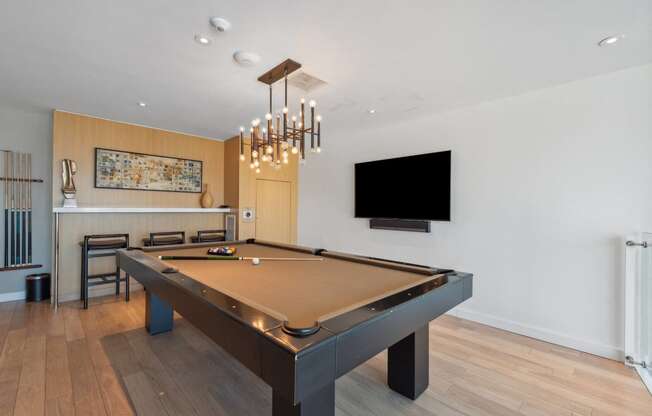 a pool table in a living room with a tv on the wall