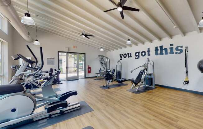 a gym with cardio equipment and a large sign that says you got this