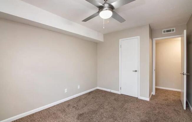 an empty room with a ceiling fan and a door at Cleo Apartments, Athens, 35611