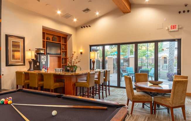 a game room with a pool table and a bar