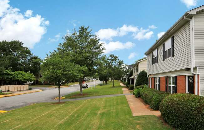 Large grass front yard leading to entrance of apartment building