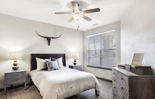 a bedroom with a bed and a ceiling fan