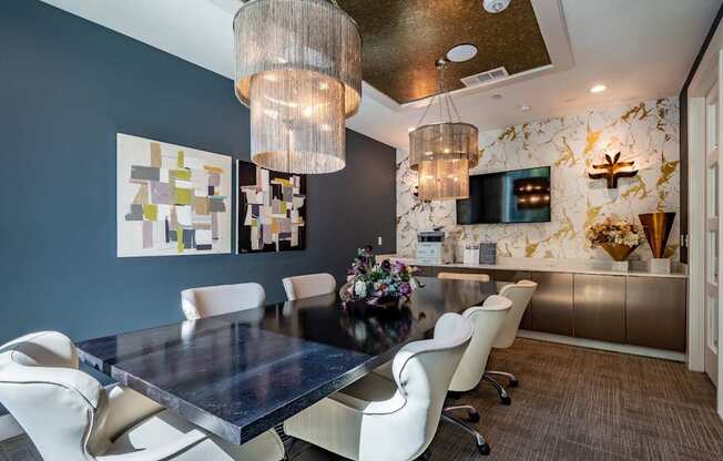 A modern dining room with a dark table and white chairs.