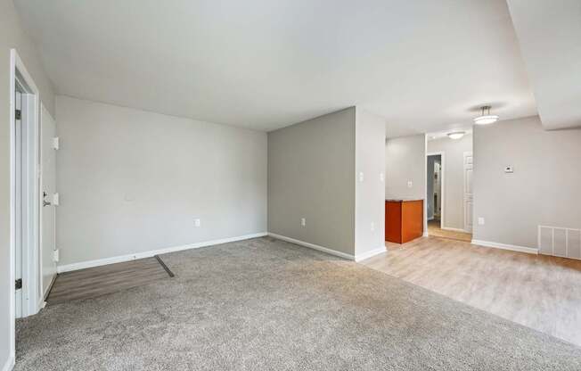 the living room and dining room in a new home with white walls and wood floors at ReNew Odenton