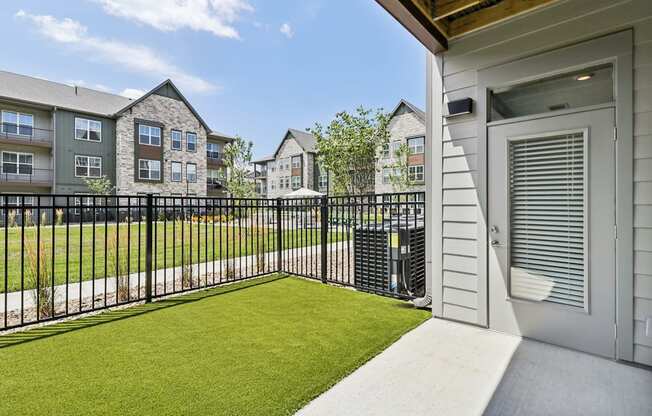 the yard of a condo with a green lawn and a fence at The Depot Raymore, MO 64083