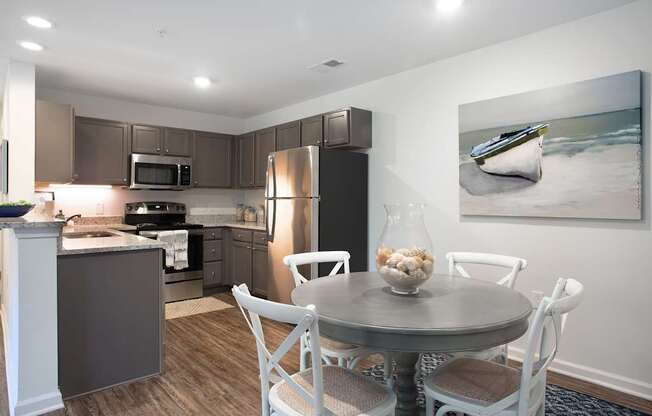 A modern kitchen with a dining table set for four.