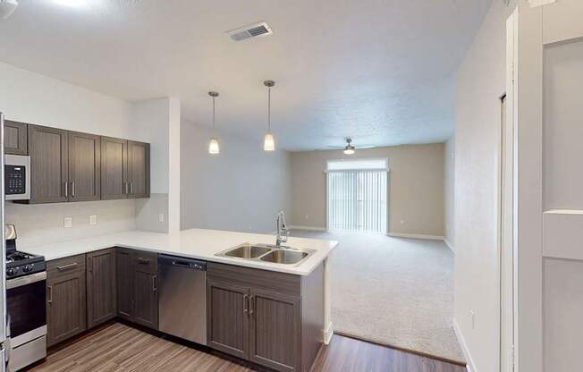 A kitchen overlooking a living room at Meadowbrooke Apartment Homes in Kentwood, MI 49512