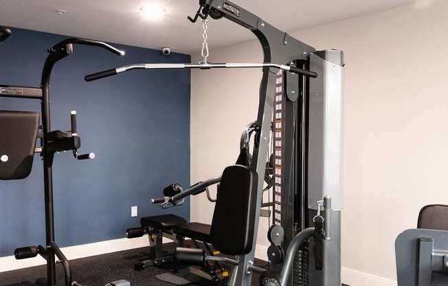 A gym with a weight machine and a bench.