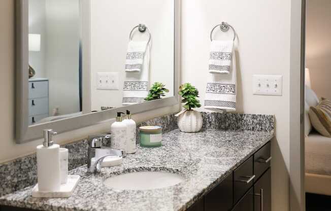 a bathroom with a granite counter top and a sink and a mirror