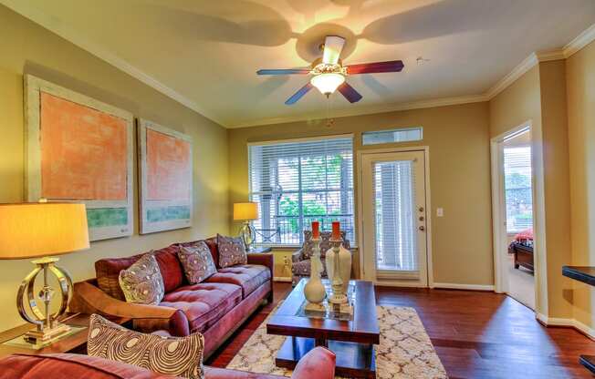 a living room with a ceiling fan and couches