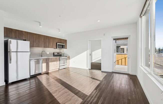 A kitchen with white appliances and wooden floors.