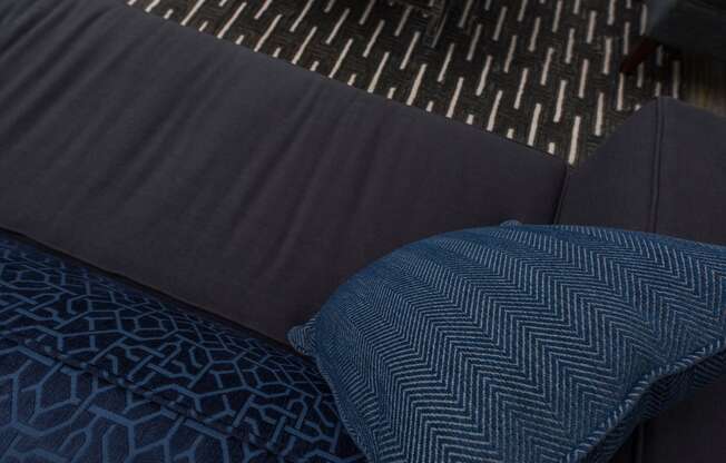a dark blue couch with a blue pillow on it
