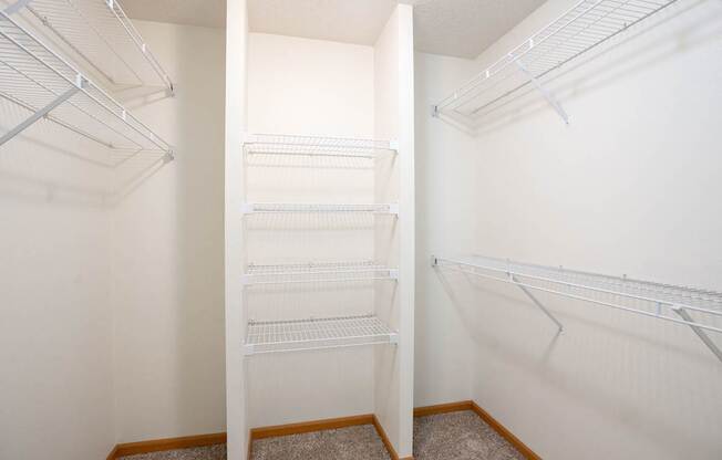 Empty white shelves in a bedrooms walk in closet. Fargo, ND Stonebridge Apartments