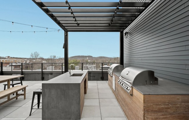 the deck has an outdoor kitchen with a grill and a table