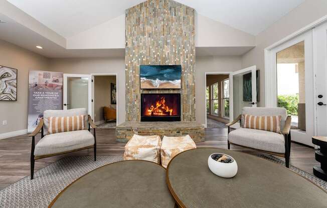 A living room with a fireplace and two chairs.