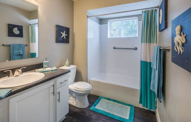 A bathroom with a white toilet, sink, and shower.