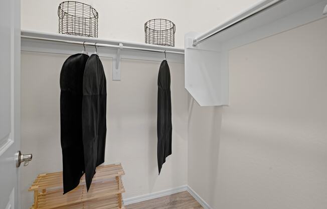 a closet with wooden steps and a black jacket hanging on the wall