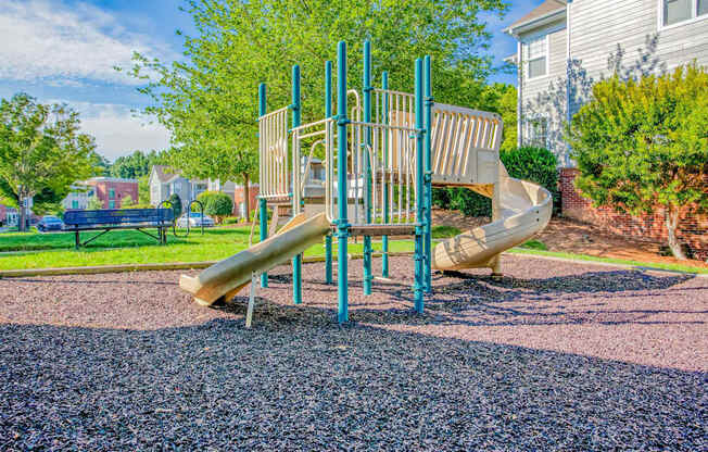 A playground with a slide and a climbing frame.