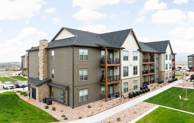 an aerial view of an apartment building with green grass and a parking lot