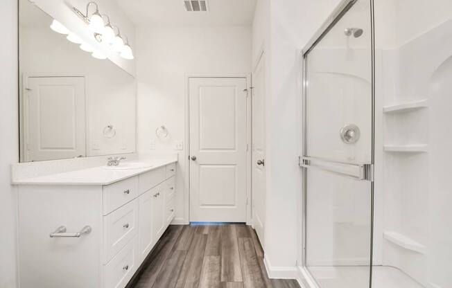 A white bathroom with a walk in shower.