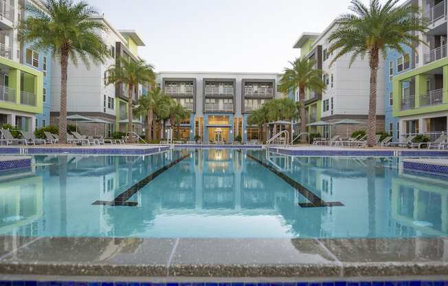Olympic-sized, resort-style swimming pool surrounded by palms at Residences at The Green