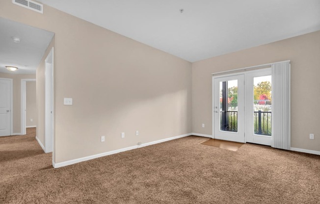 a bedroom with a door to a balcony and a carpeted floor