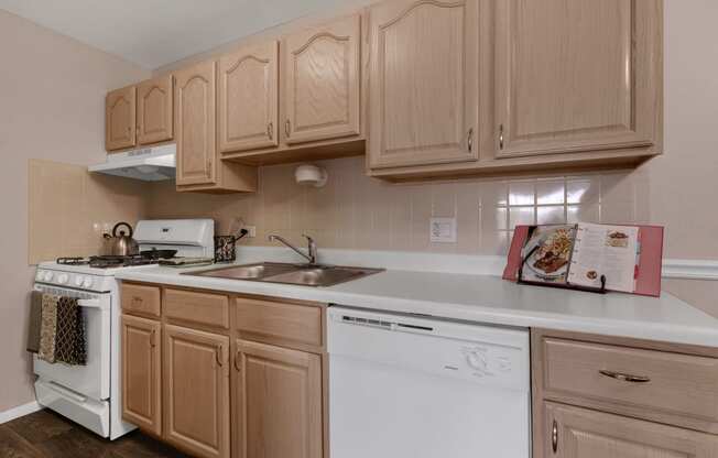a kitchen with white appliances and wooden cabinets at St Charles Square Apartments, Carol Stream