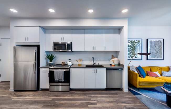 a kitchen with white cabinets and a stainless steel refrigerator