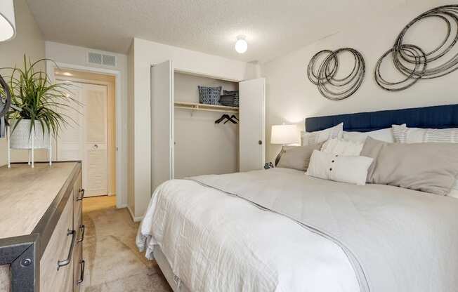 A bedroom with a large bed and a white wall.
