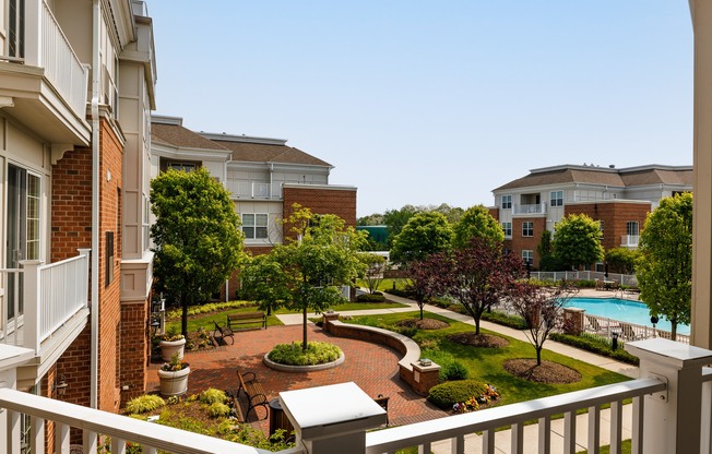 A view of a courtyard from a balcony with a pool in the background.