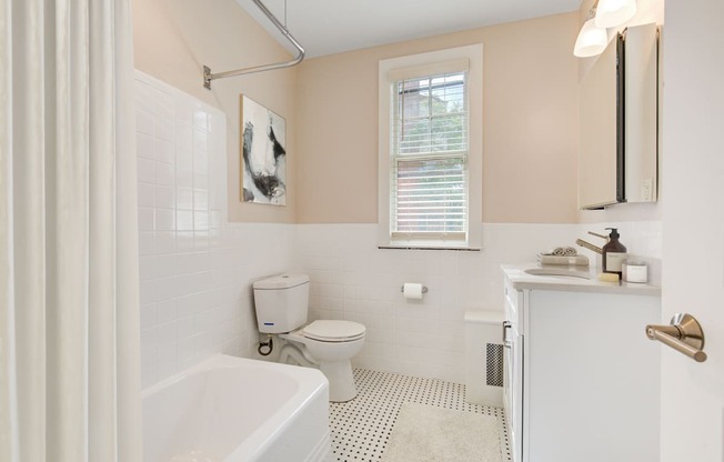 a bathroom with a toilet and a tub and a sink