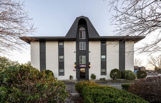 Kent apartments exterior photo with bushes.