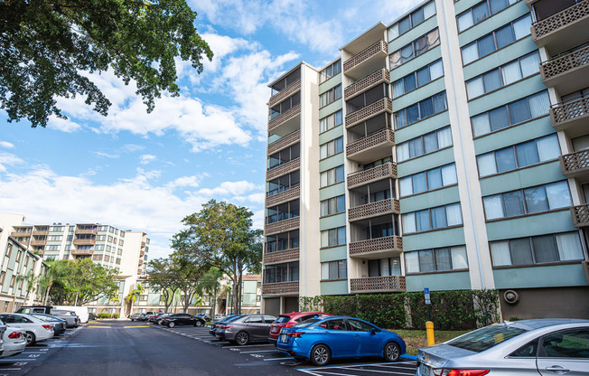 a city street with cars parked in front of an apartment building at Fairways of Inverrary, Lauderhill, Florida