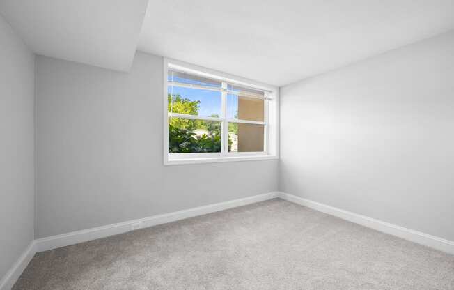 an empty room with white walls and a window