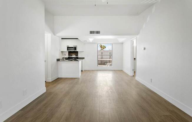 A kitchen with white cabinets and a wooden floor.