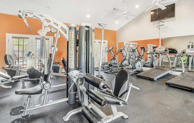 a gym with cardio machines and weights on the floor and a tv at Reserve of Jackson Apartment Homes, Jackson, 39211