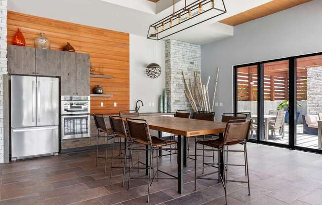 A kitchen with a wooden wall and a table with chairs.