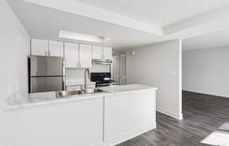 A kitchen with white cabinets and a white countertop.