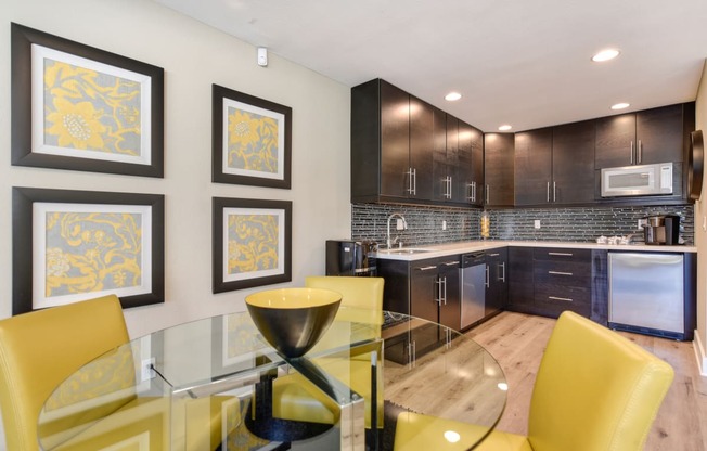 Community leasing office with bright yellow chairs around a round glass table.